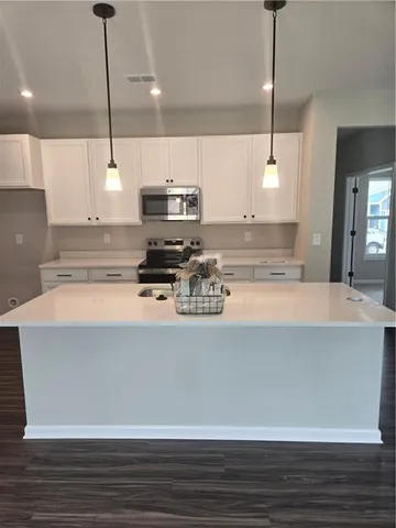 a kitchen with kitchen island a counter a stove and a wooden floors