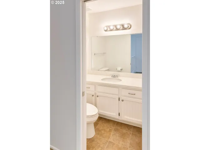a view of bathroom with a toilet sink and mirror