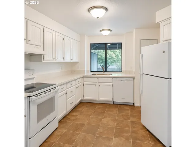 a kitchen with a white cabinets and white appliances