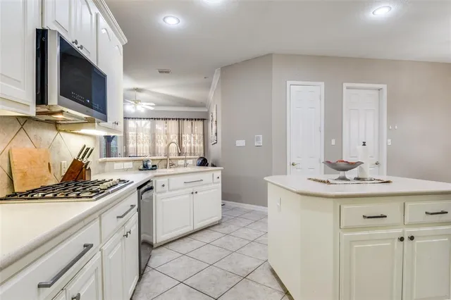 a kitchen with stainless steel appliances kitchen island granite countertop a sink and cabinets