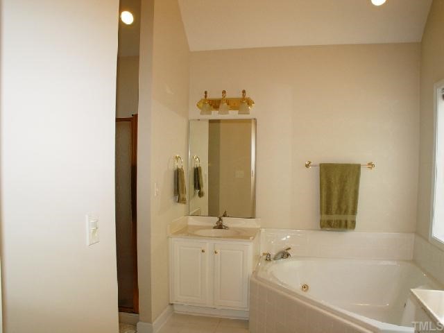 1509 Patterson Grove Road Apex, NC 27502 - Photo 8 of 12 Spa-like master bath has separated his and hers vanities by the corner whirlpool tub. There is also a separate shower and water closet for privacy.
