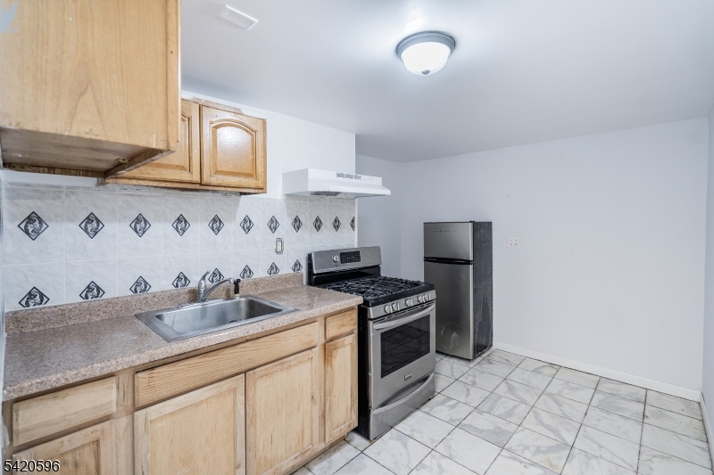 904 2nd Avenue, Unit 2 Elizabeth, NJ 07201 - Photo 14 of 19 a kitchen with granite countertop a sink stove and cabinets