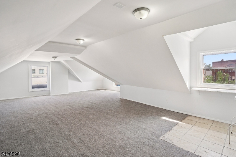 904 2nd Avenue, Unit 2 Elizabeth, NJ 07201 - Photo 5 of 19 an empty room with windows and stairs