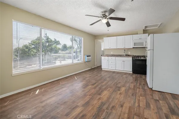 a open kitchen with wooden floor and stainless steel appliances