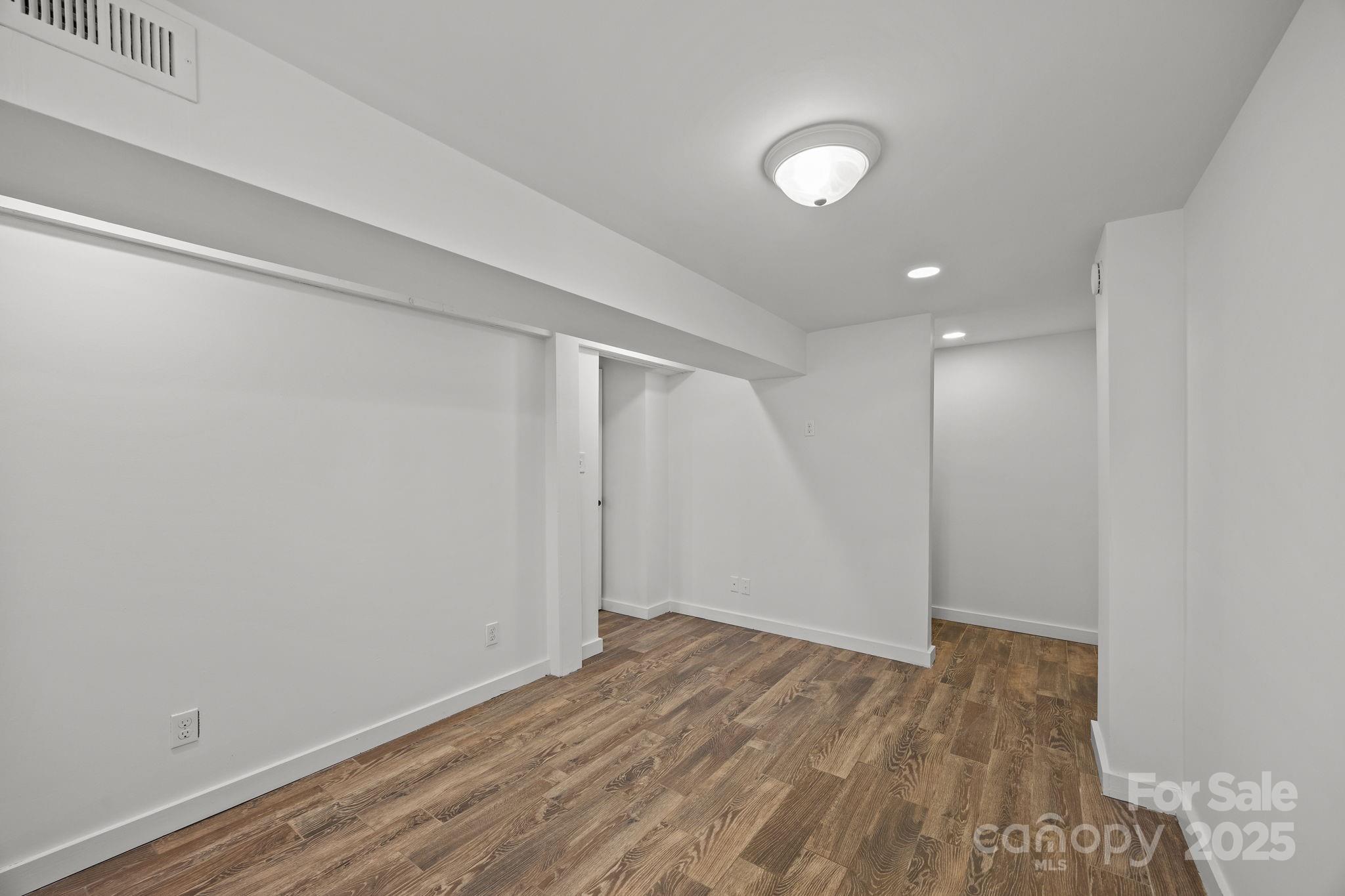 175 Chatham Road Asheville, NC 28804 - Photo 37 of 48 a view of an empty room with wooden floor and a window