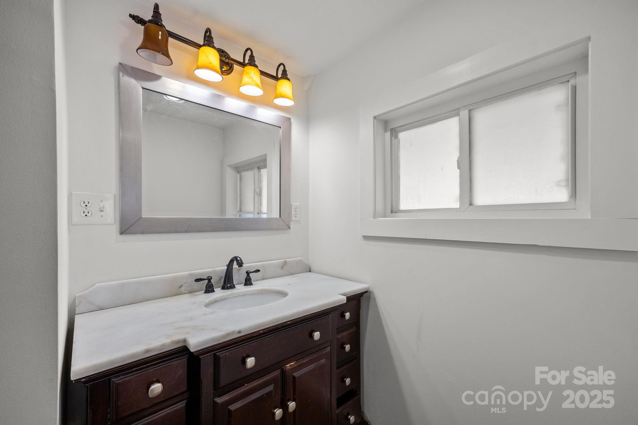 175 Chatham Road Asheville, NC 28804 - Photo 39 of 48 a bathroom with a granite countertop sink a light fixture and a mirror