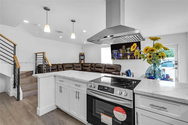 a kitchen with a stove a sink and a chandelier