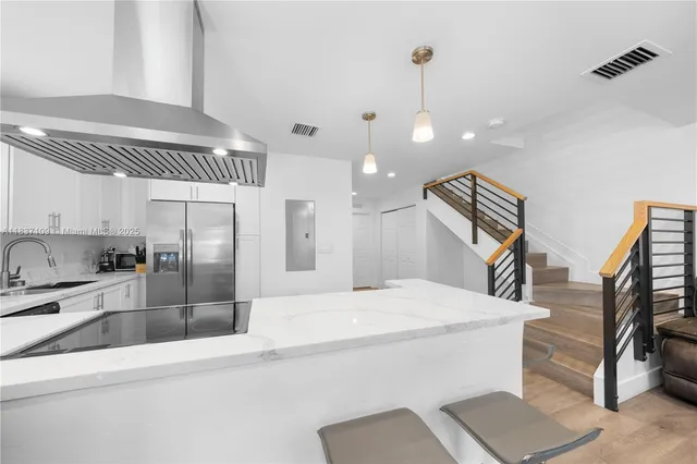 a kitchen with stainless steel appliances kitchen island a refrigerator and a sink