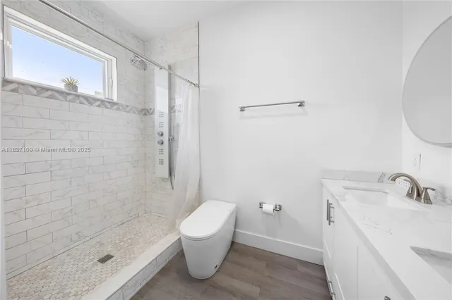 a bathroom with a sink a toilet and shower