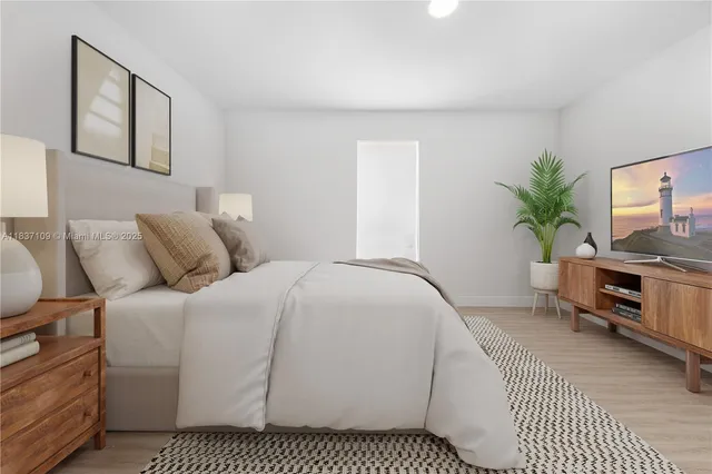 a bedroom with a bed and a flat screen tv