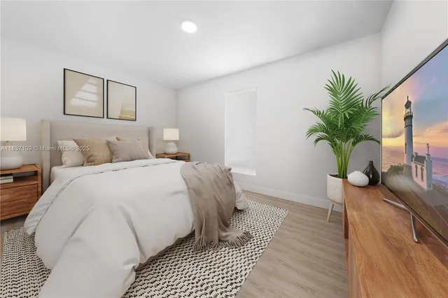 a bedroom with a large bed and a potted plant