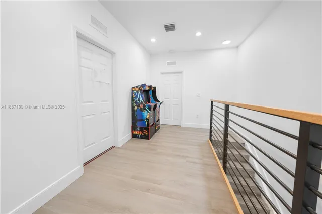 a view of hallway with stairs and wooden floor