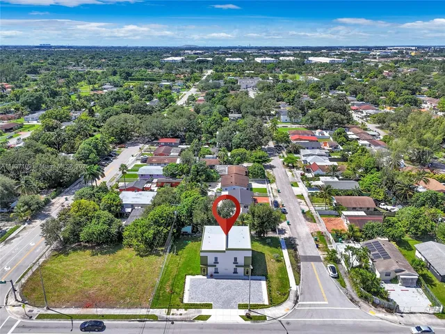 an aerial view of residential houses with outdoor space and ocean view