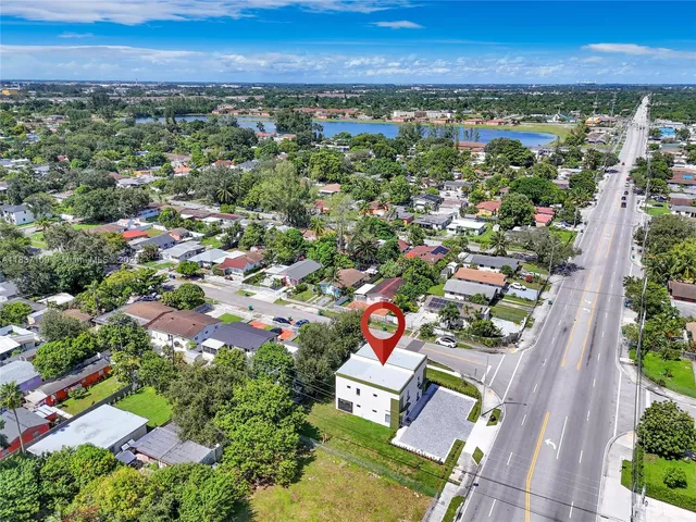 an aerial view of residential house with outdoor space and trees all around