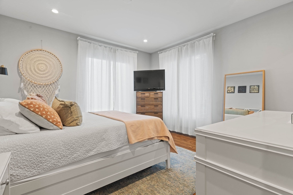 6 Ashland Street, Unit 3 Boston, MA 02122 - Photo 13 of 25 a bedroom with a bed and a chandelier