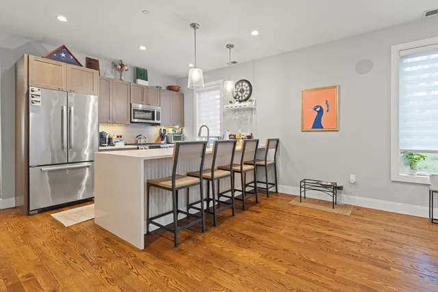 a kitchen with stainless steel appliances kitchen island granite countertop a refrigerator and a stove top oven