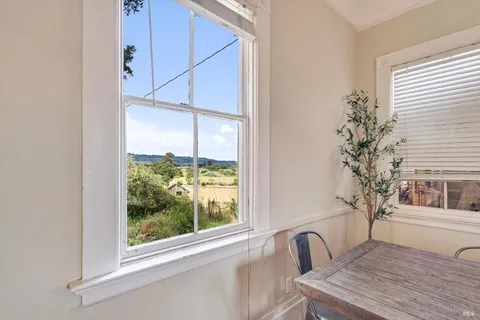 a view of a room that has a window and a table in it