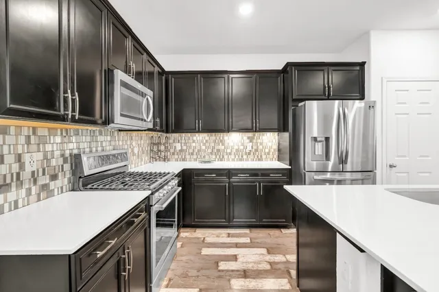 a kitchen with stainless steel appliances a sink stove and refrigerator