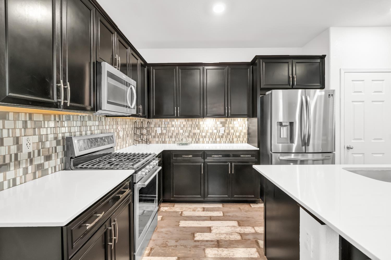 8193 Kramer Ranch Way Elk Grove, CA 95758 - Photo 12 of 48 a kitchen with stainless steel appliances a sink stove and refrigerator