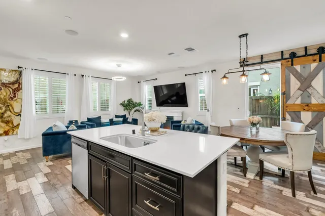 a kitchen with a stove a sink a dining table and chairs
