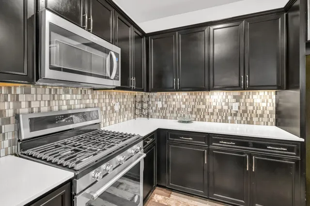 a kitchen with granite countertop a stove sink and cabinets
