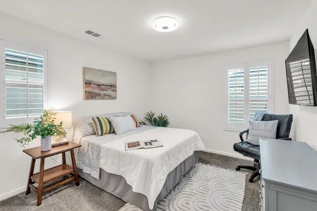 a bedroom with a bed a table and chair