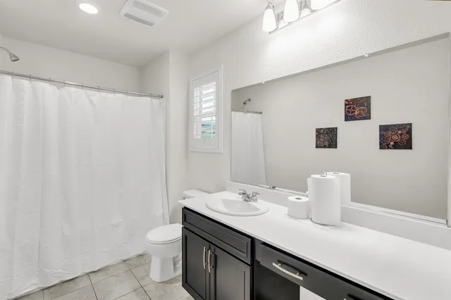 a bathroom with a sink a toilet and shower curtain