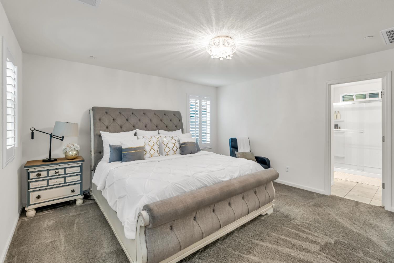 8193 Kramer Ranch Way Elk Grove, CA 95758 - Photo 28 of 48 a bedroom with a bed and a chandelier