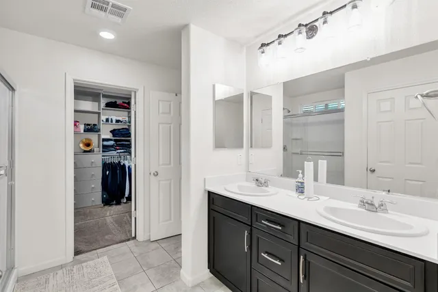 a bathroom with a double vanity sink and a mirror