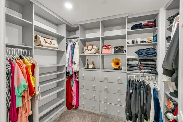 a view of walk in closet with clothes and shoes