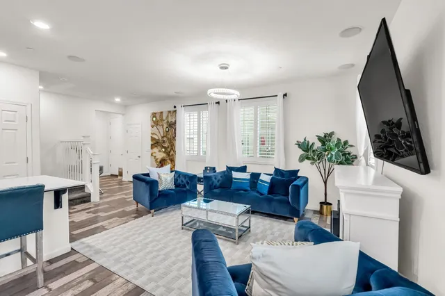 a living room with furniture a large window and wooden floor