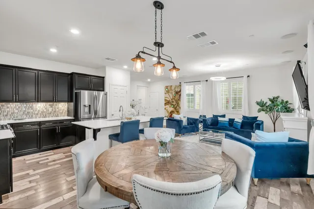 a large kitchen with kitchen island a sink appliances and a dining table