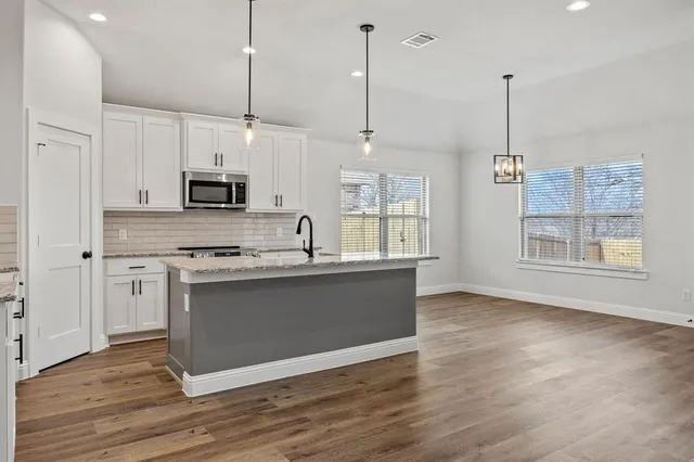 a kitchen with white cabinets stainless steel appliances and sink
