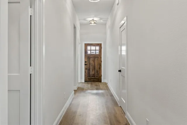 a view of a hallway with wooden floor