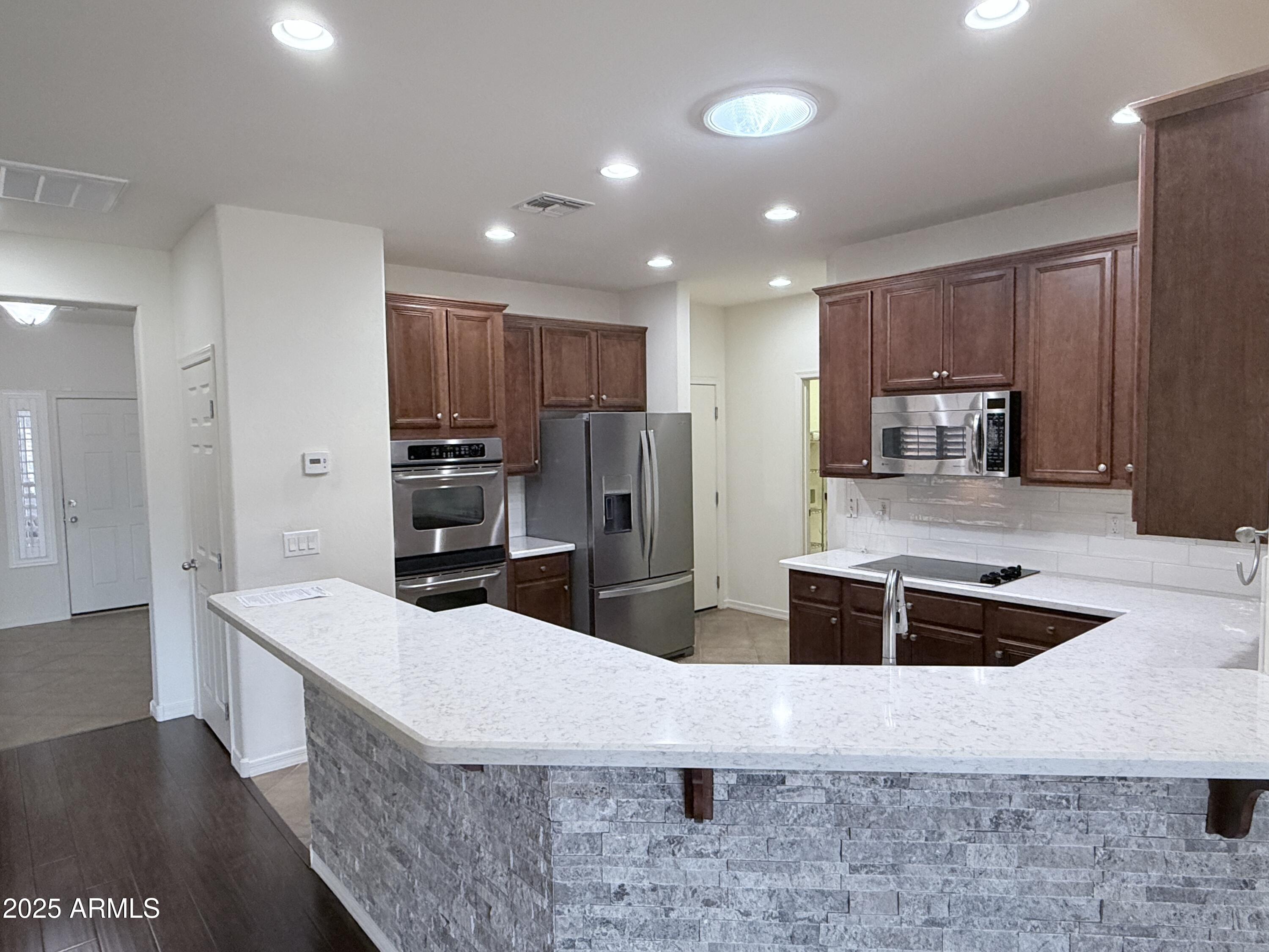 16549 West Rowel Road Surprise, AZ 85387 - Photo 12 of 23 a large kitchen with stainless steel appliances