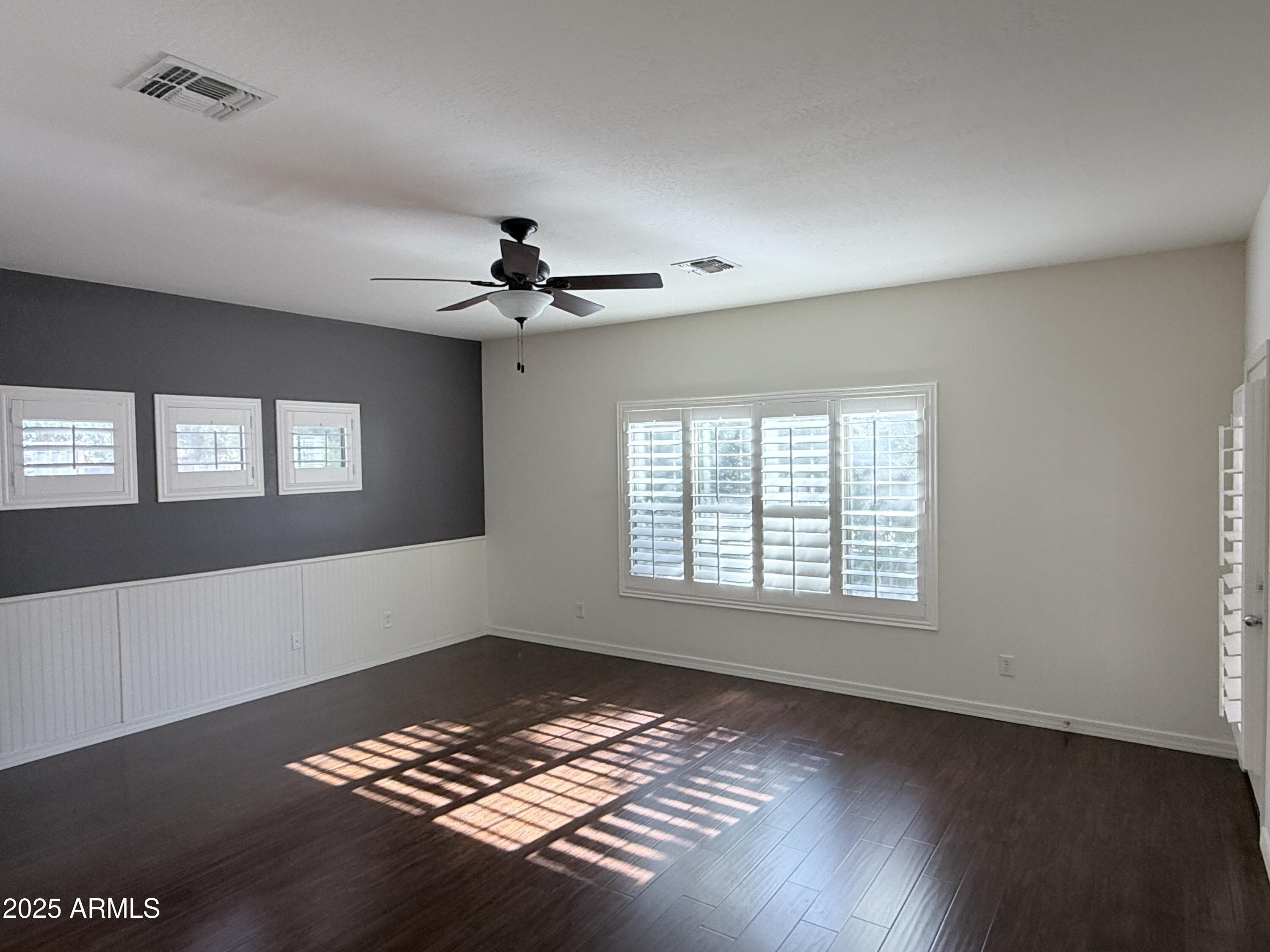16549 West Rowel Road Surprise, AZ 85387 - Photo 13 of 23 a view of an empty room with a window and wooden floor