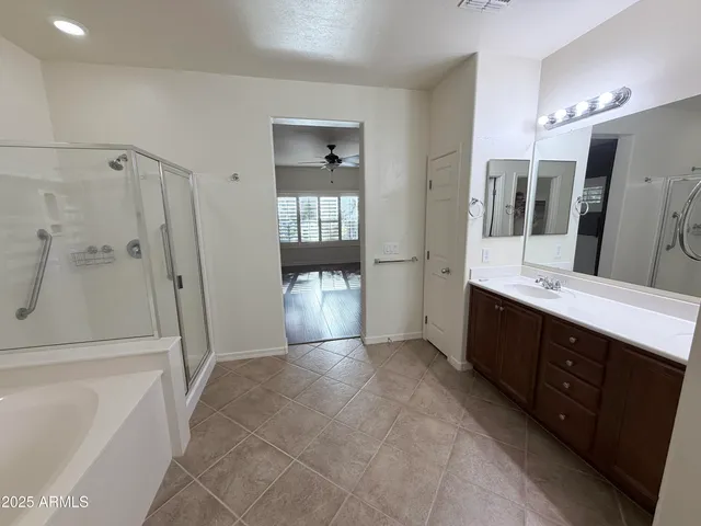a spacious bathroom with a double vanity sink a mirror and shower