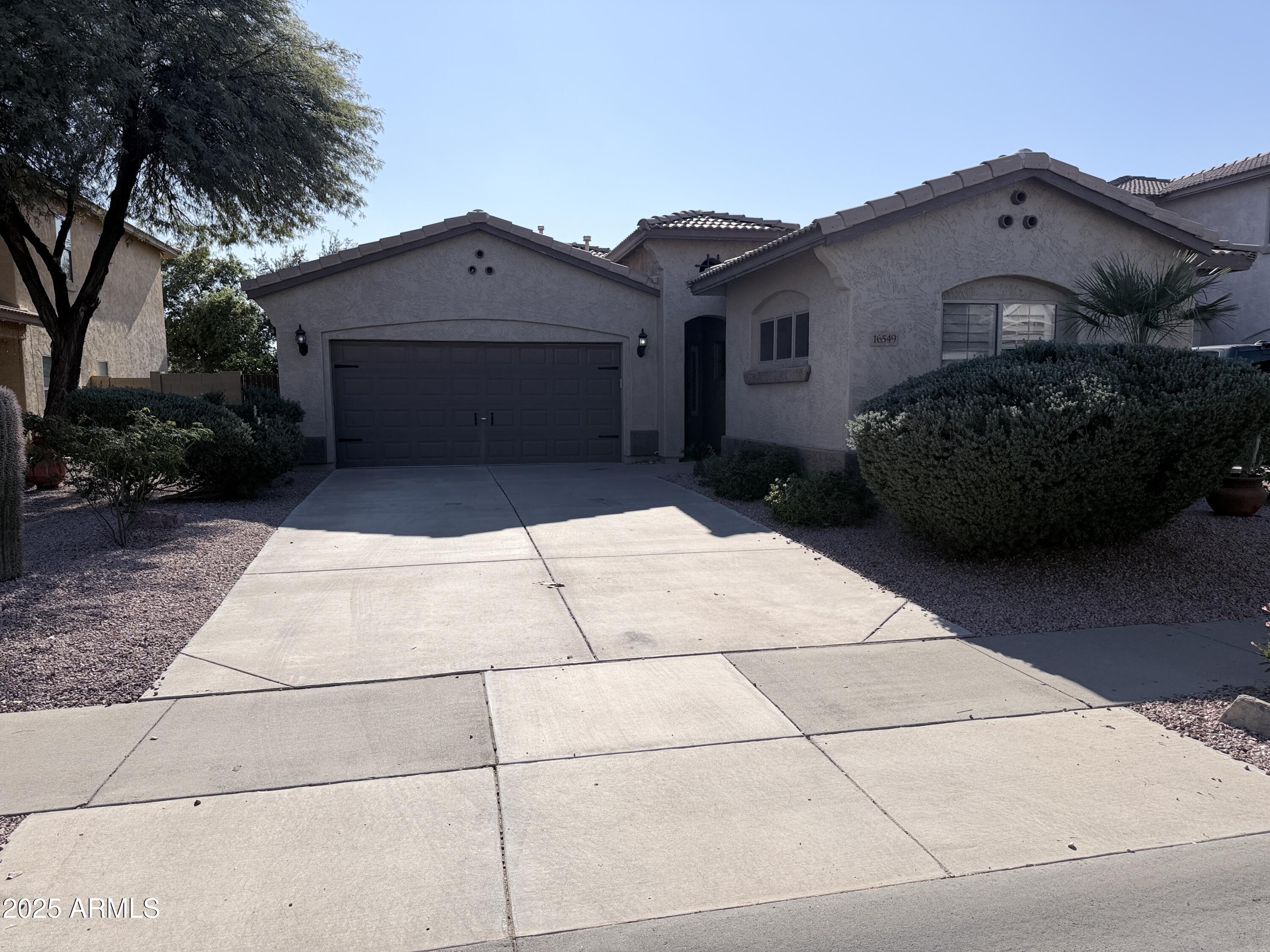 16549 West Rowel Road Surprise, AZ 85387 - Photo 2 of 23 a front view of a house with a garden