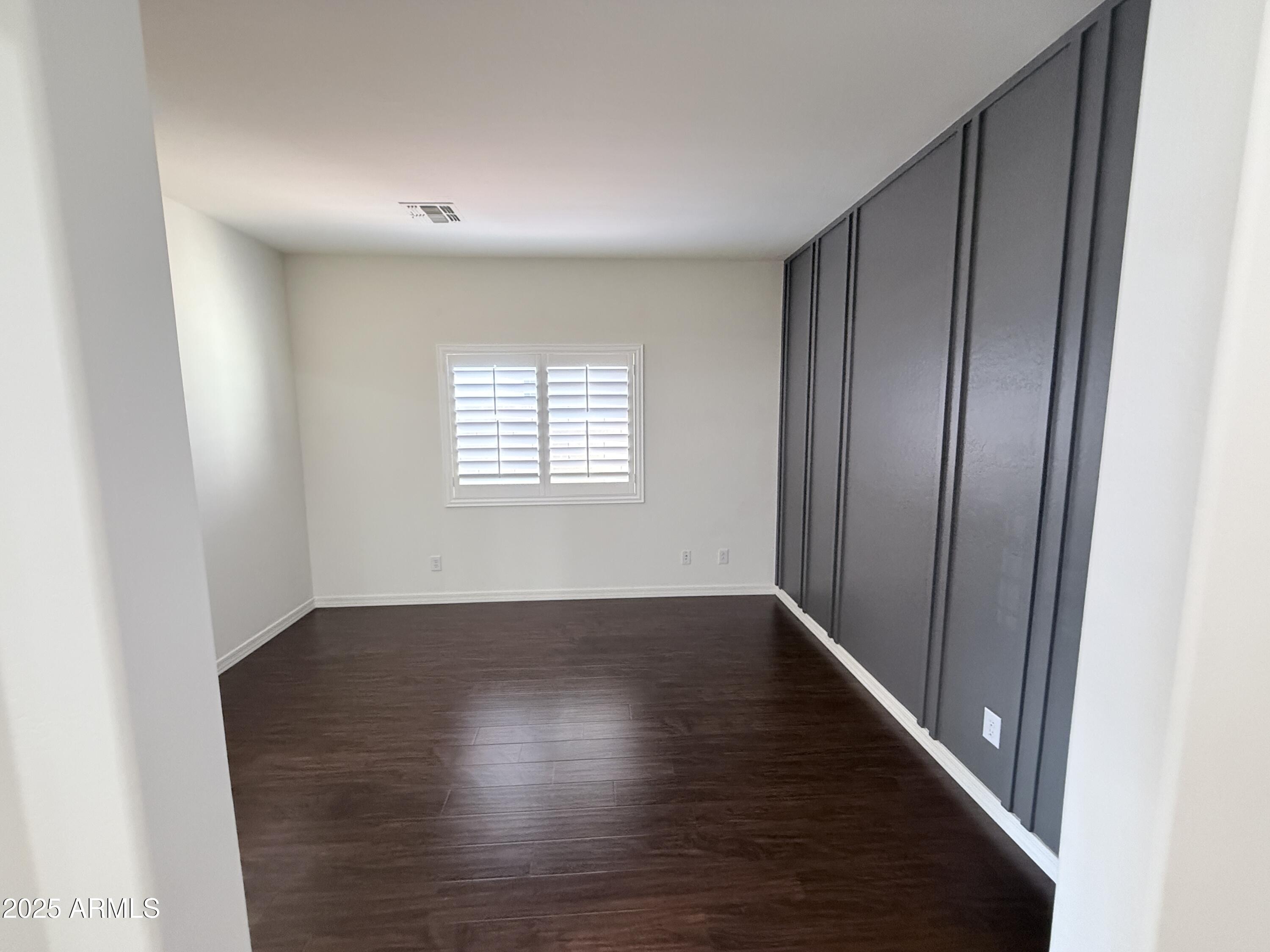 16549 West Rowel Road Surprise, AZ 85387 - Photo 7 of 23 an empty room with wooden floor and windows