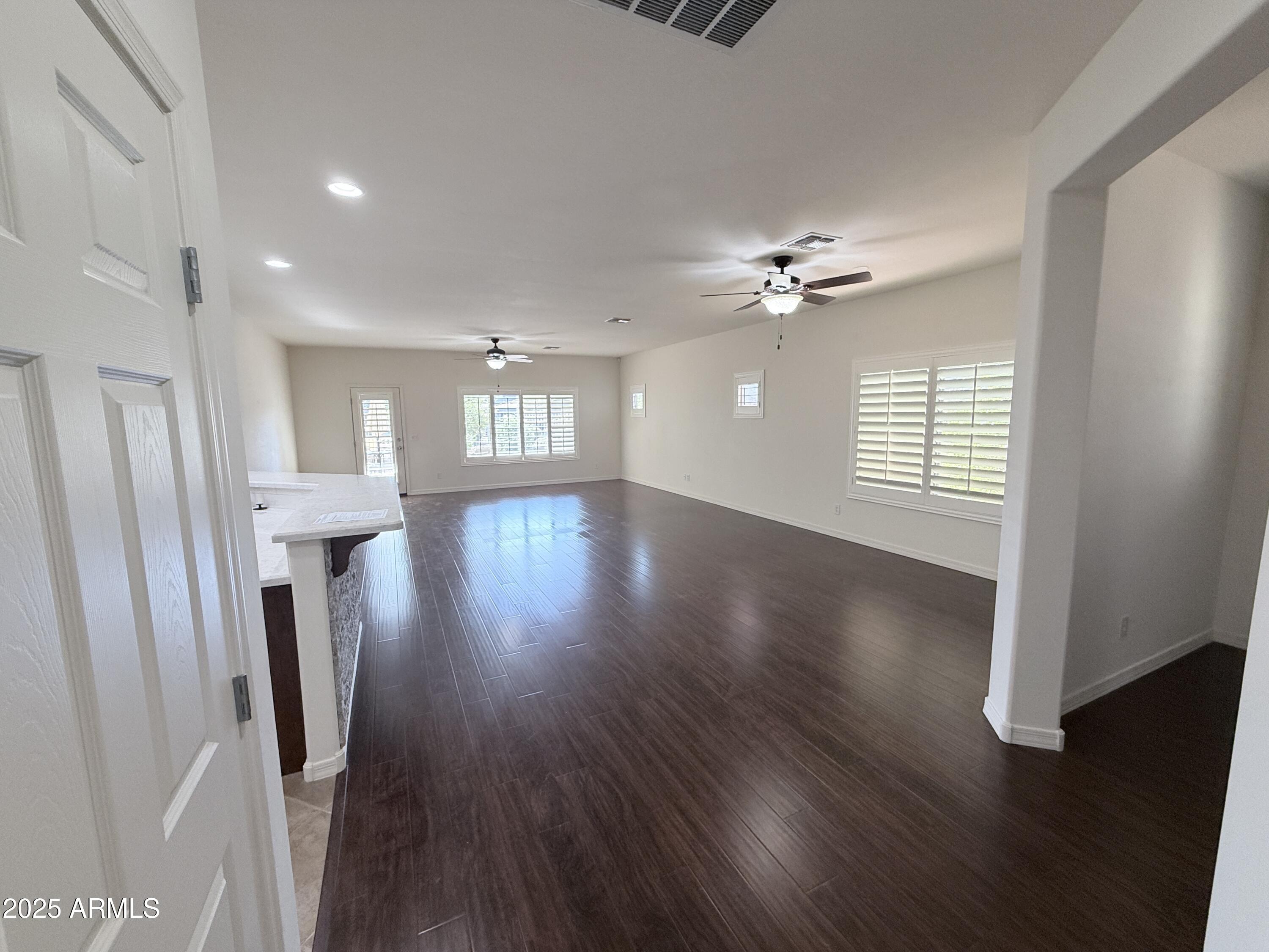 16549 West Rowel Road Surprise, AZ 85387 - Photo 8 of 23 an empty room with wooden floor and windows