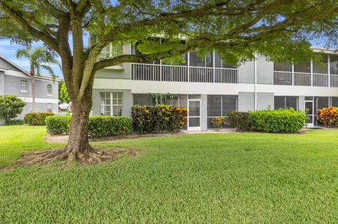 an aerial view of a residential houses with outdoor space and a lake view in back