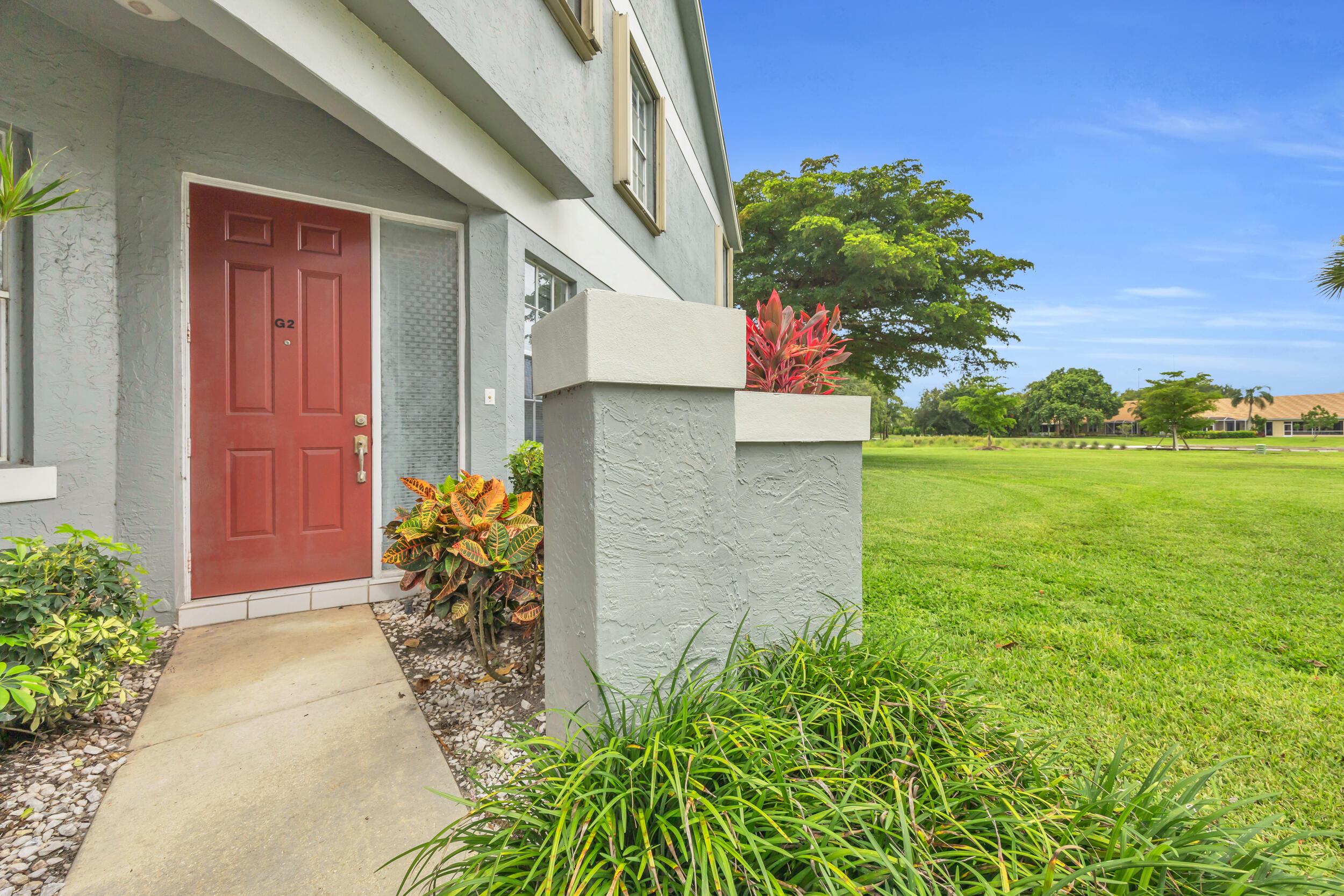 10172 Andover Coach Circle, Unit G2 Lake Worth, FL 33449 - Photo 4 of 64 a vase with flowers sitting in front of a door