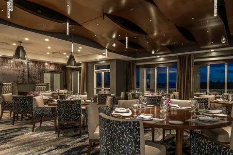 a room with a table chairs and a workspace