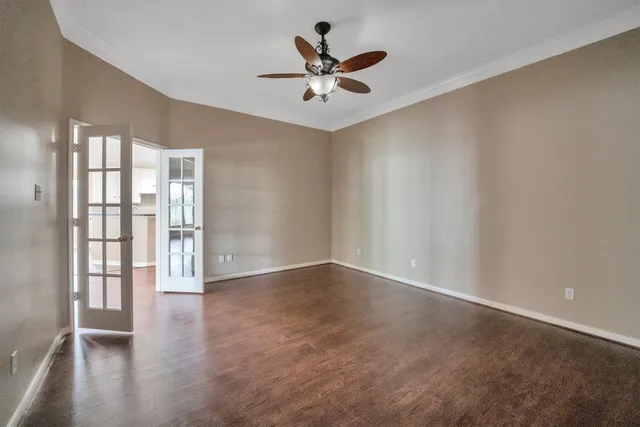 an empty room with wooden floor and windows