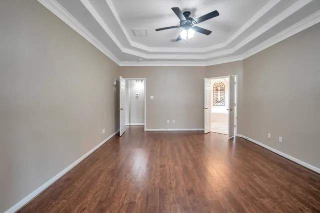a view of an empty room with wooden floor fireplace and a window