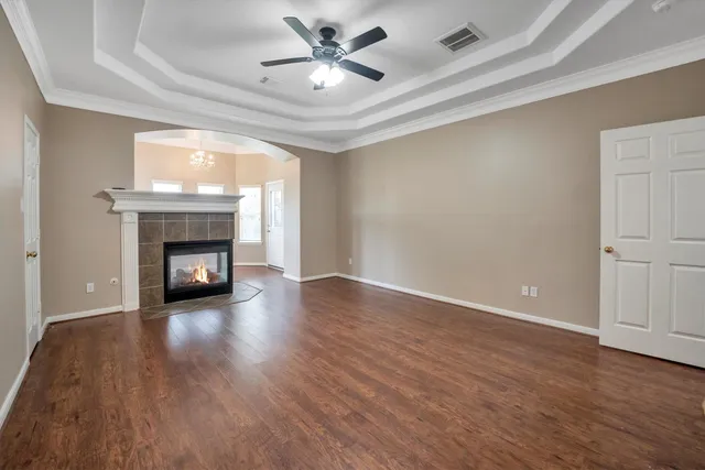 a view of an empty room with a window and a kitchen