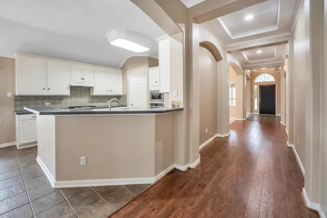 a view of a big room with windows and chandelier