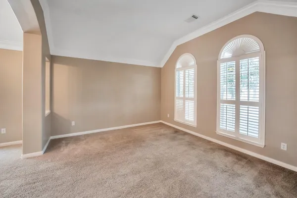 a view of a livingroom with a chandelier fan and windows