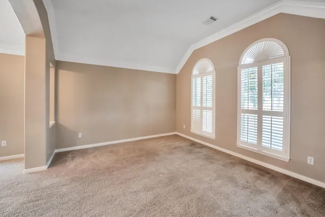 a view of a livingroom with a chandelier fan and windows