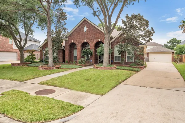 a front view of a house with a yard and trees